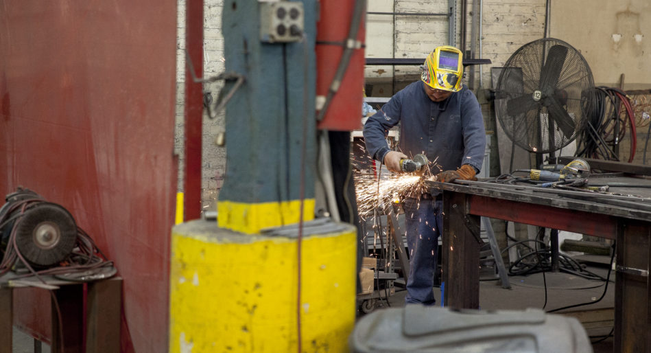 工厂工人在芝加哥高地伊利诺伊州定制制造商使用金属管研磨工具